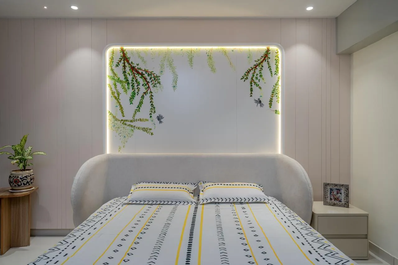 A bedroom with a backlit foliage panel behind the bed